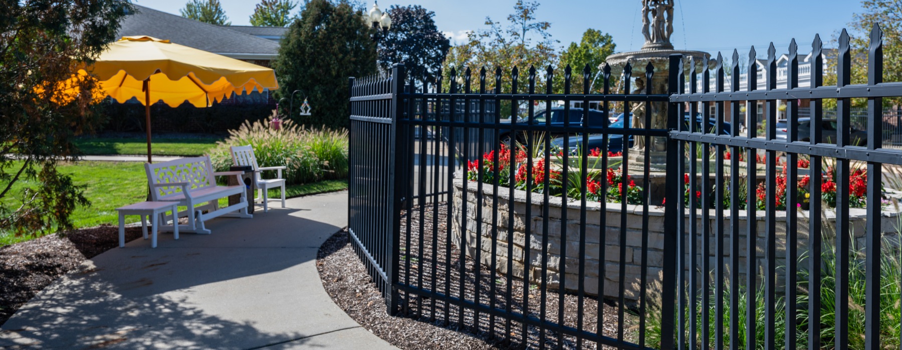 Outside yard with fence, umbrella, and chairs